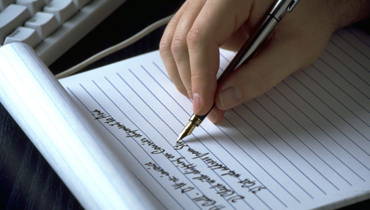 persona escribiendo lista en cuaderno