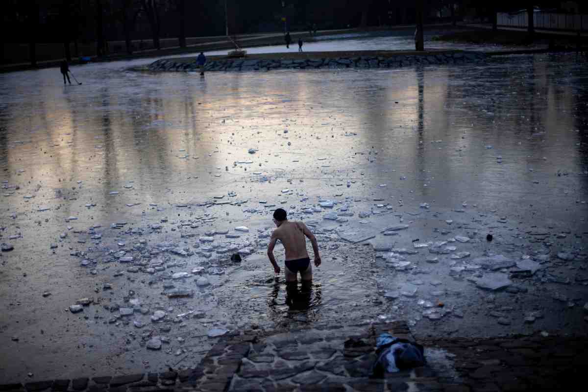 Hombre se vaya en uno de los estanques congelados de Praga en temperaturas bajo cero.