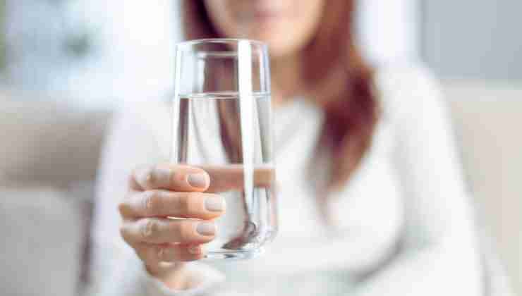 mujer con vaso de agua en mano