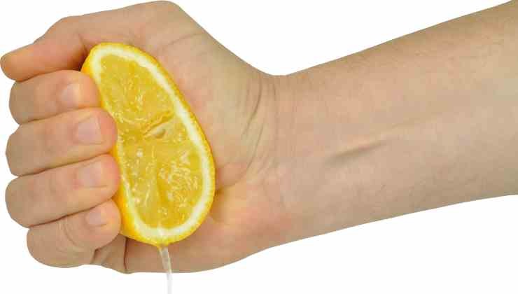 mano exprimiendo limón