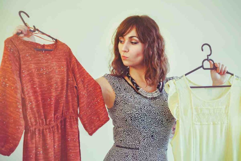 donna indecisa tra due capi d'abbigliamento