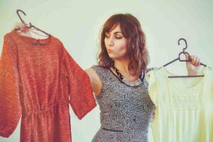 donna indecisa tra due capi d'abbigliamento