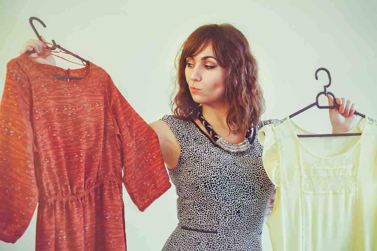 donna indecisa tra due capi d'abbigliamento