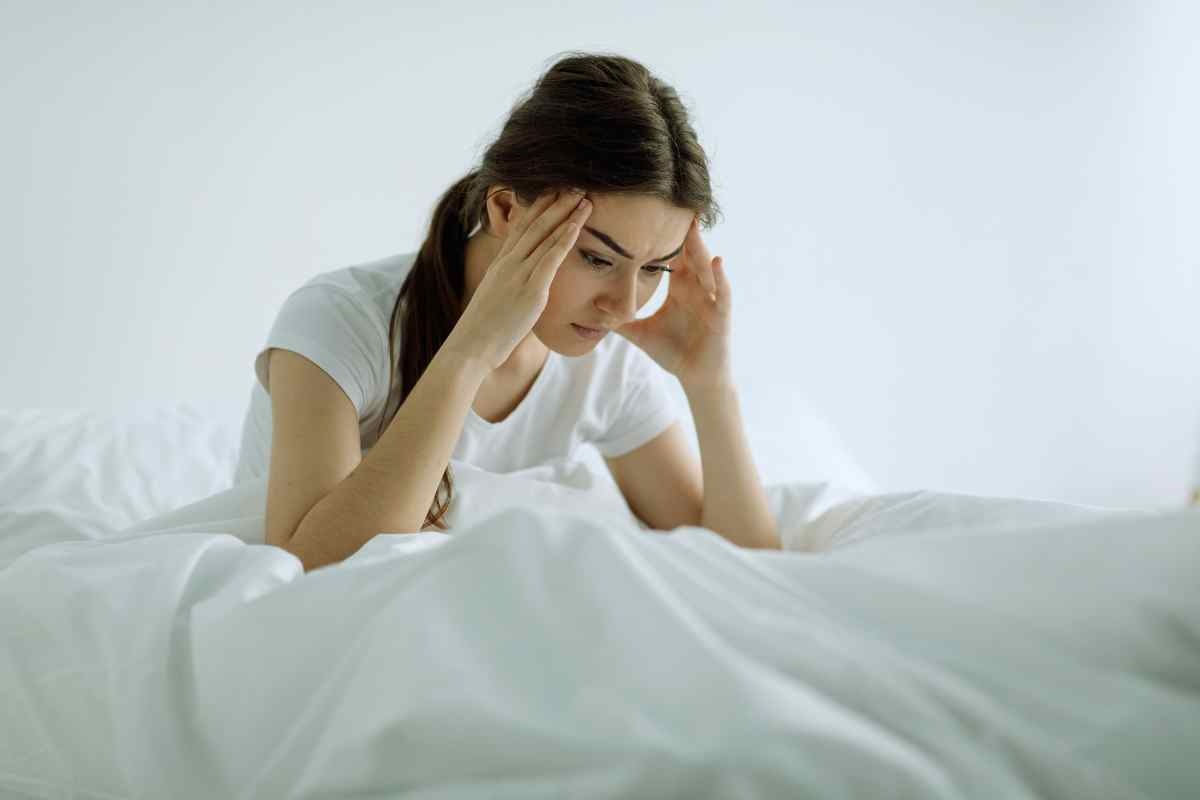 donna preoccupata sul letto 