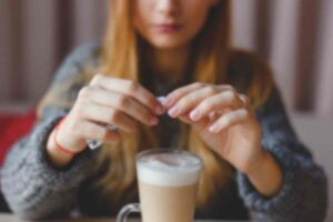ragazza aggiunge dello zucchero nel cappuccino