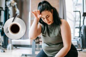 donna in palestra e tazzina di caffè