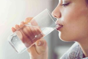 donna che beve un bicchiere d'acqua