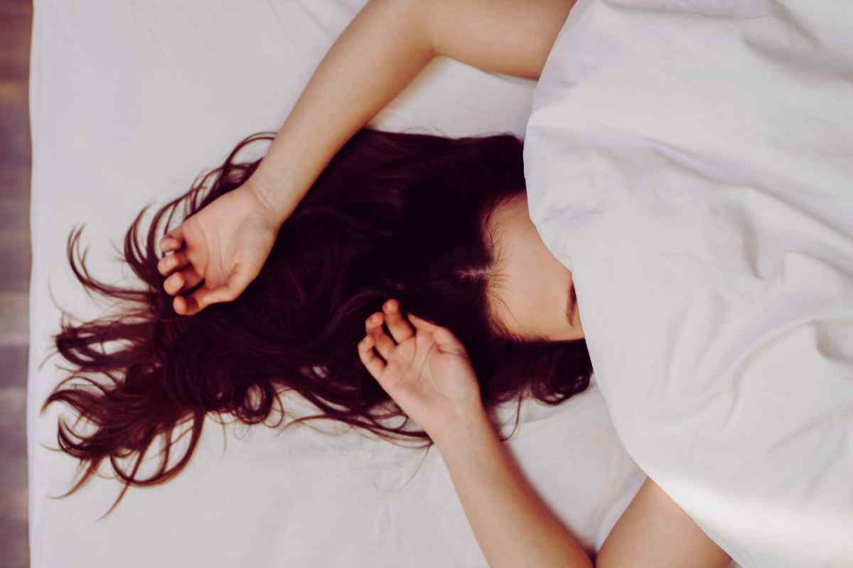mujer durmiendo bajo las sábanas