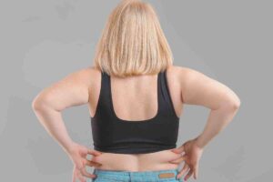 donna di spalle che si tocca maniglie dell'amore