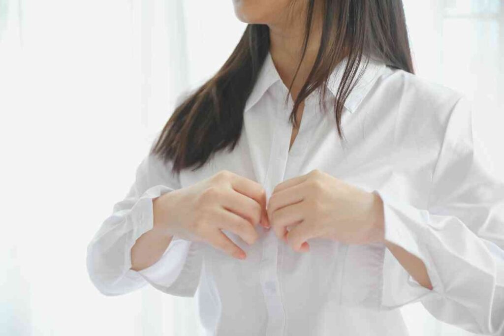 donna che si allaccia la camicia