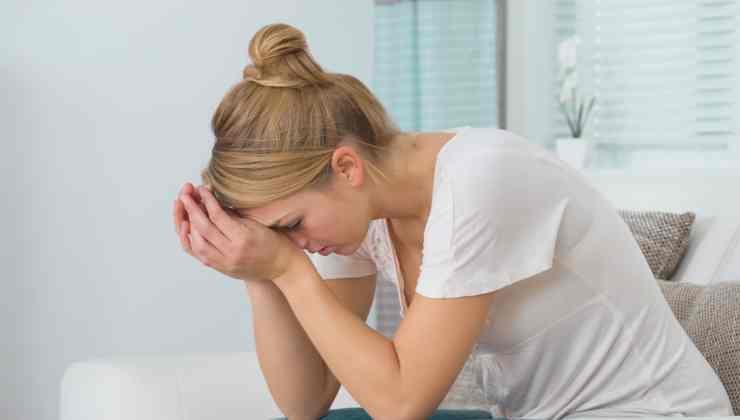 mujer inclinada con las manos en la cara