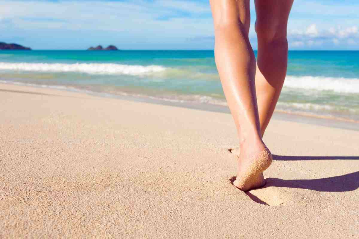 piernas caminando por la playa