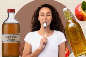 persona con cucchiaio e aceto di mele