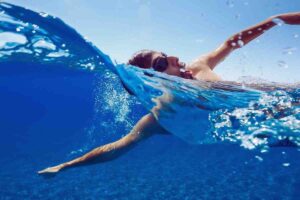 uomo che nuota al mare