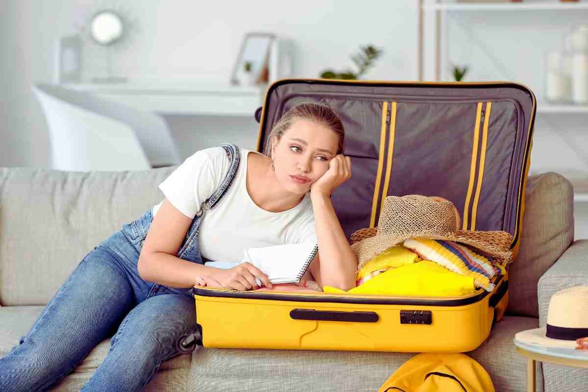 ragazza appoggiata sulla valigia