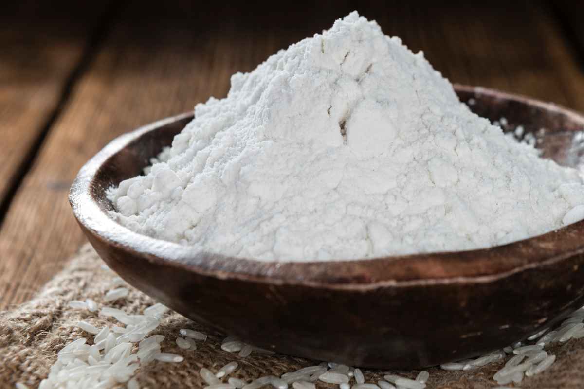Ciotola di legno con farina di riso bianco senza glutine
