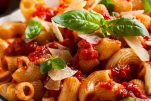 Piatto di pasta senza glutine condita con pomodoro e basilico