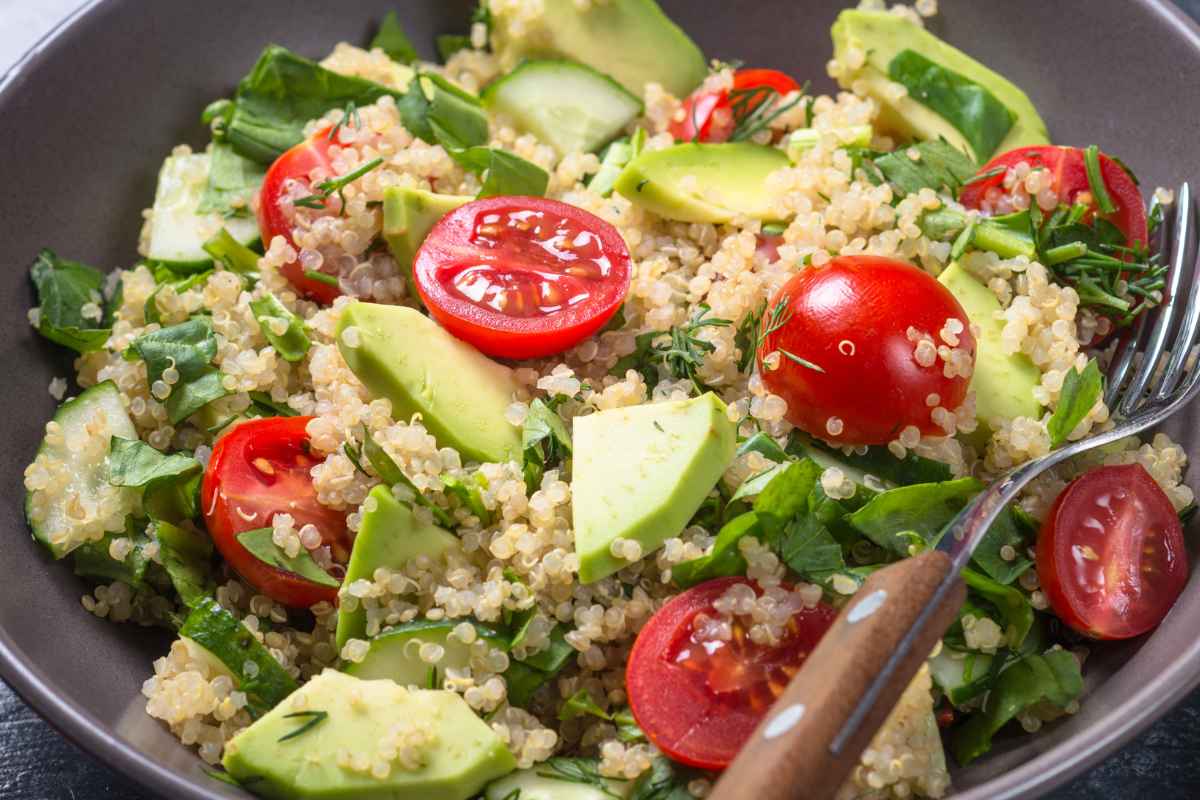 Piatto fondo con all'interno una Insalata di quinoa con pomodori e avocado