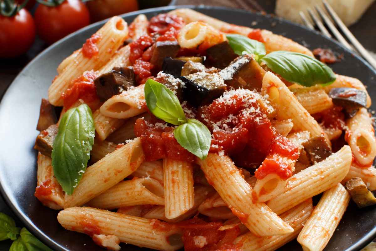 Primo piano di un piatto di pasta alla Norma fatto con le melanzane arrosto invece che fritte