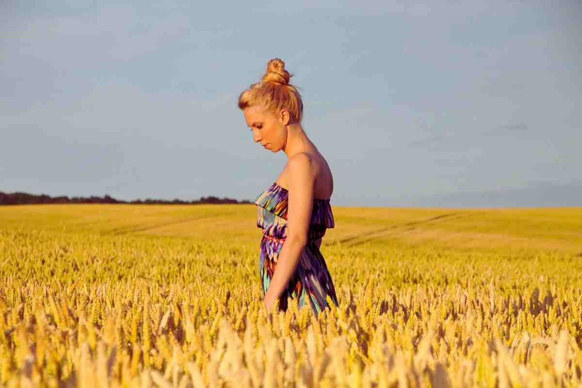 donna triste in mezzo a un campo di grano