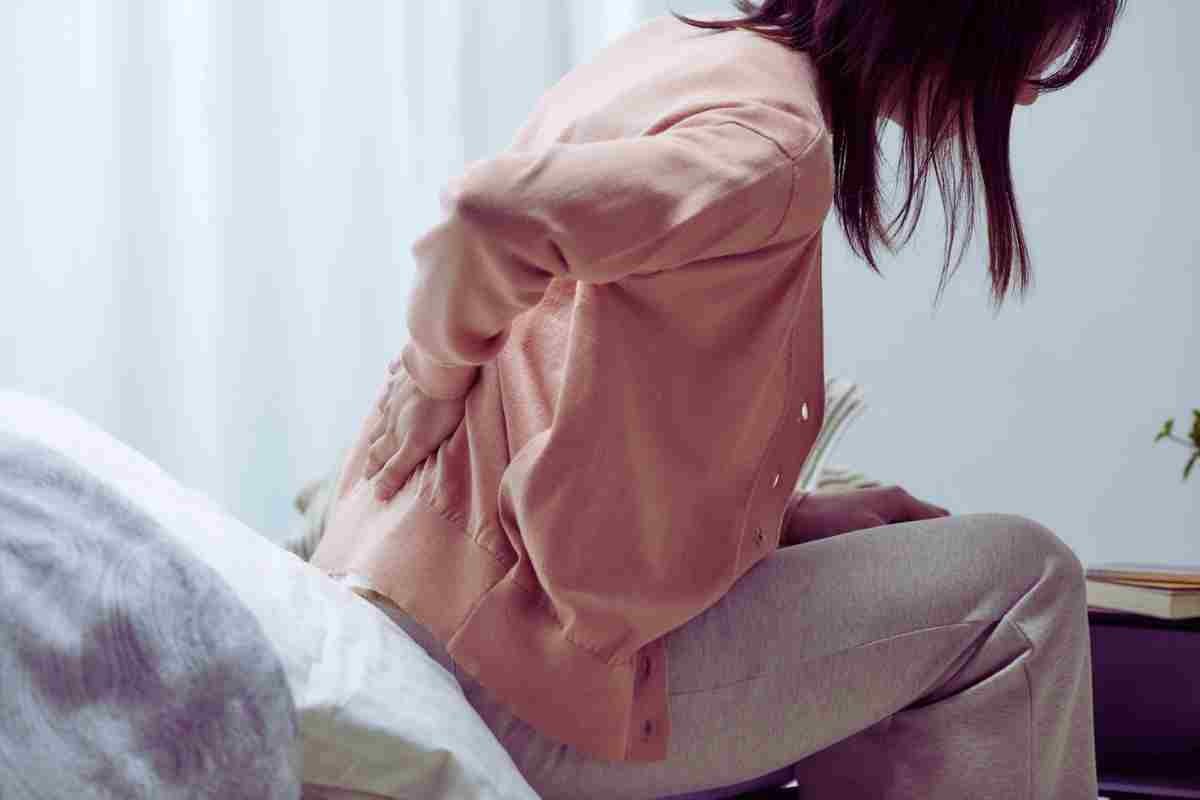 mujer en cama con dolores